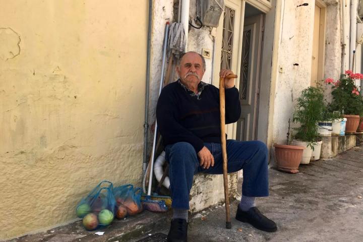 a man sitting on a bench in front of a building