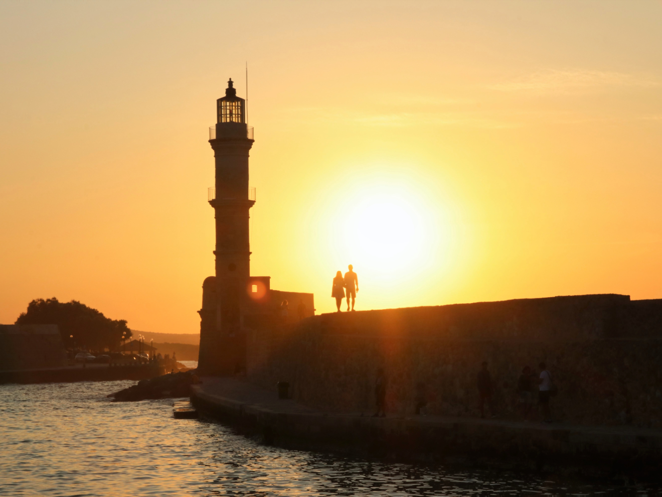 a large ship in a body of water with a sunset in the background