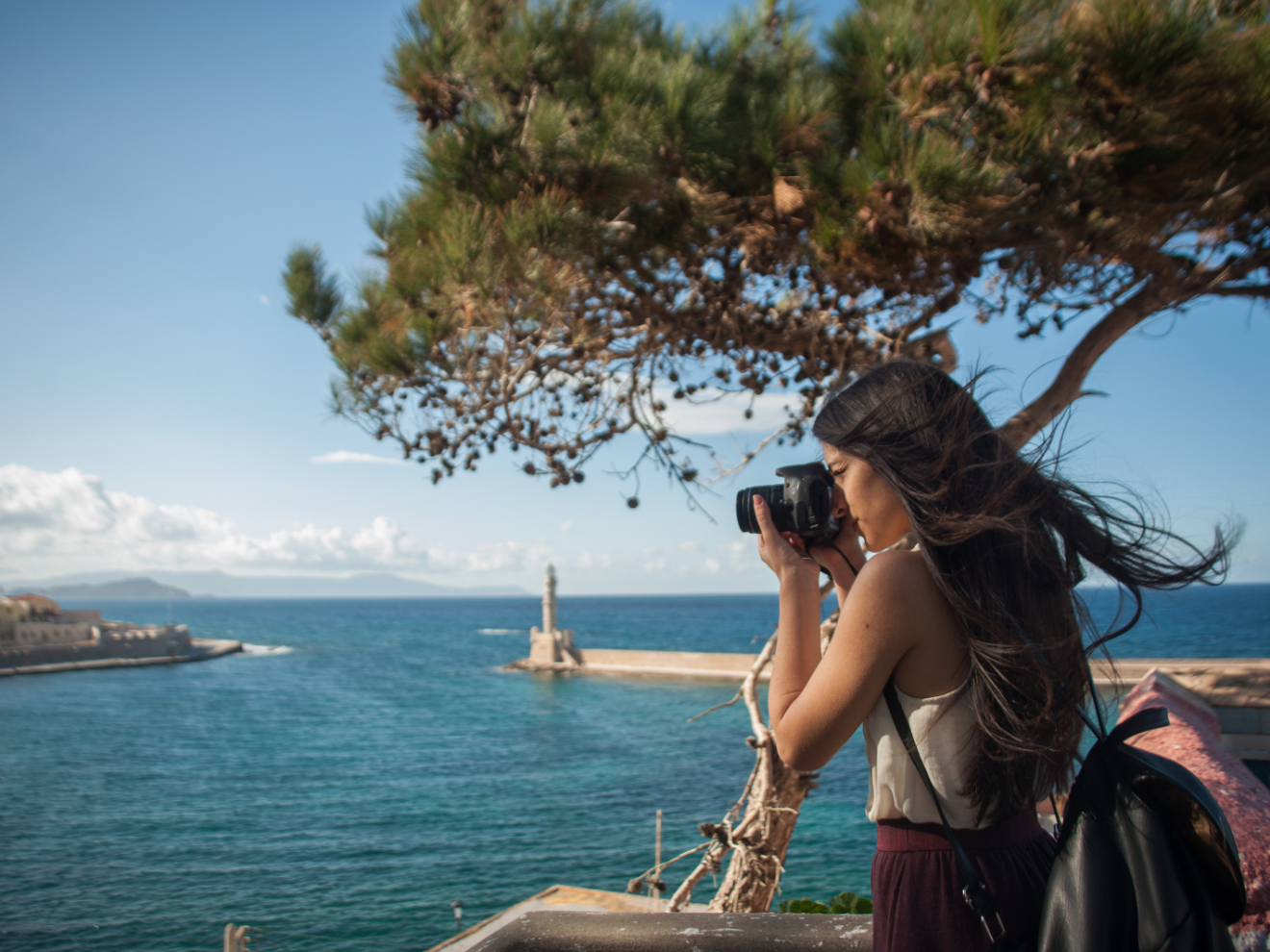a woman standing next to a body of water