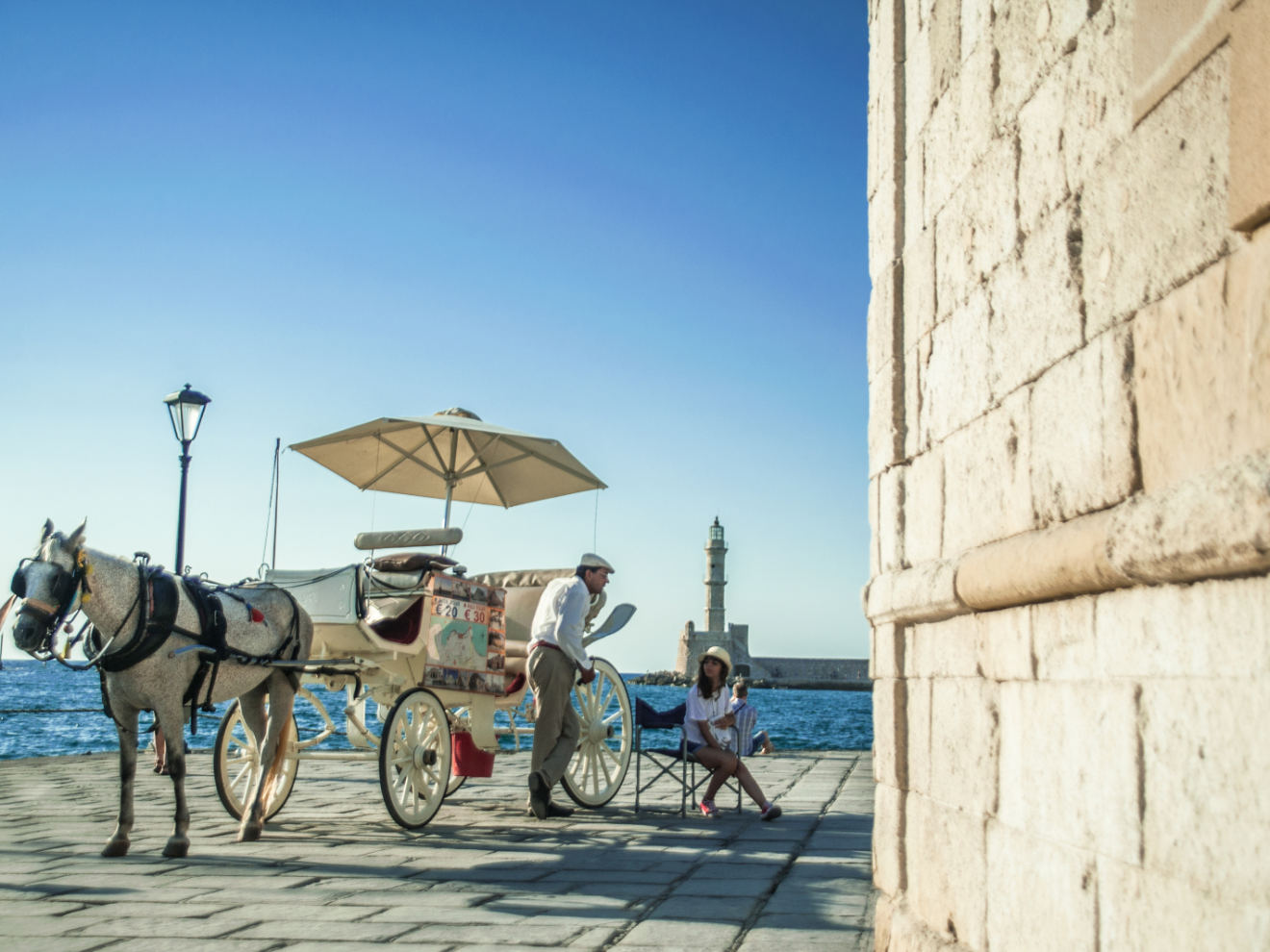 a person riding a horse drawn carriage in front of a building