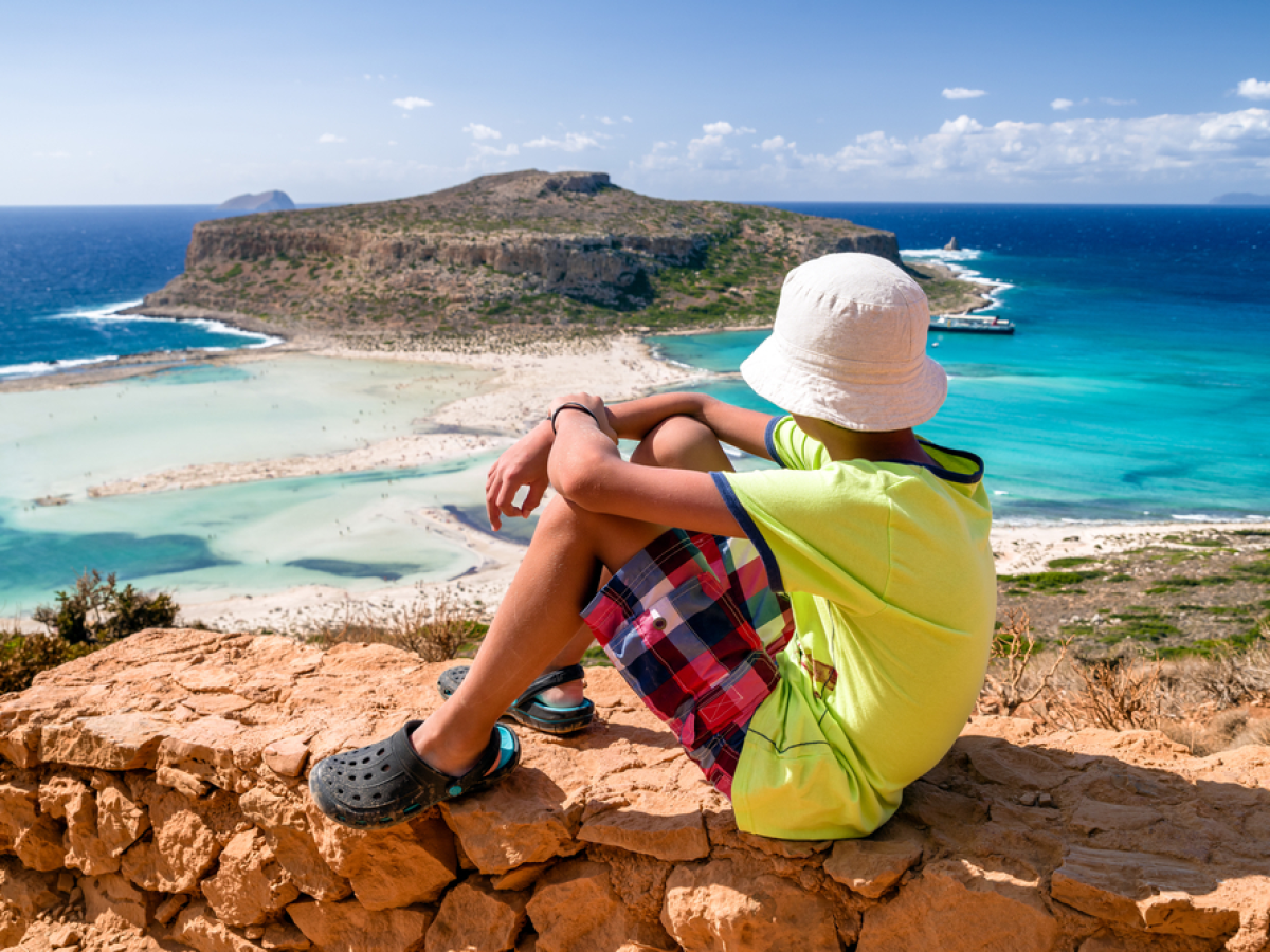 a person sitting on a rock near the ocean