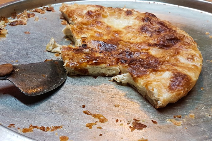 a slice of pizza sitting on top of a pan on a table