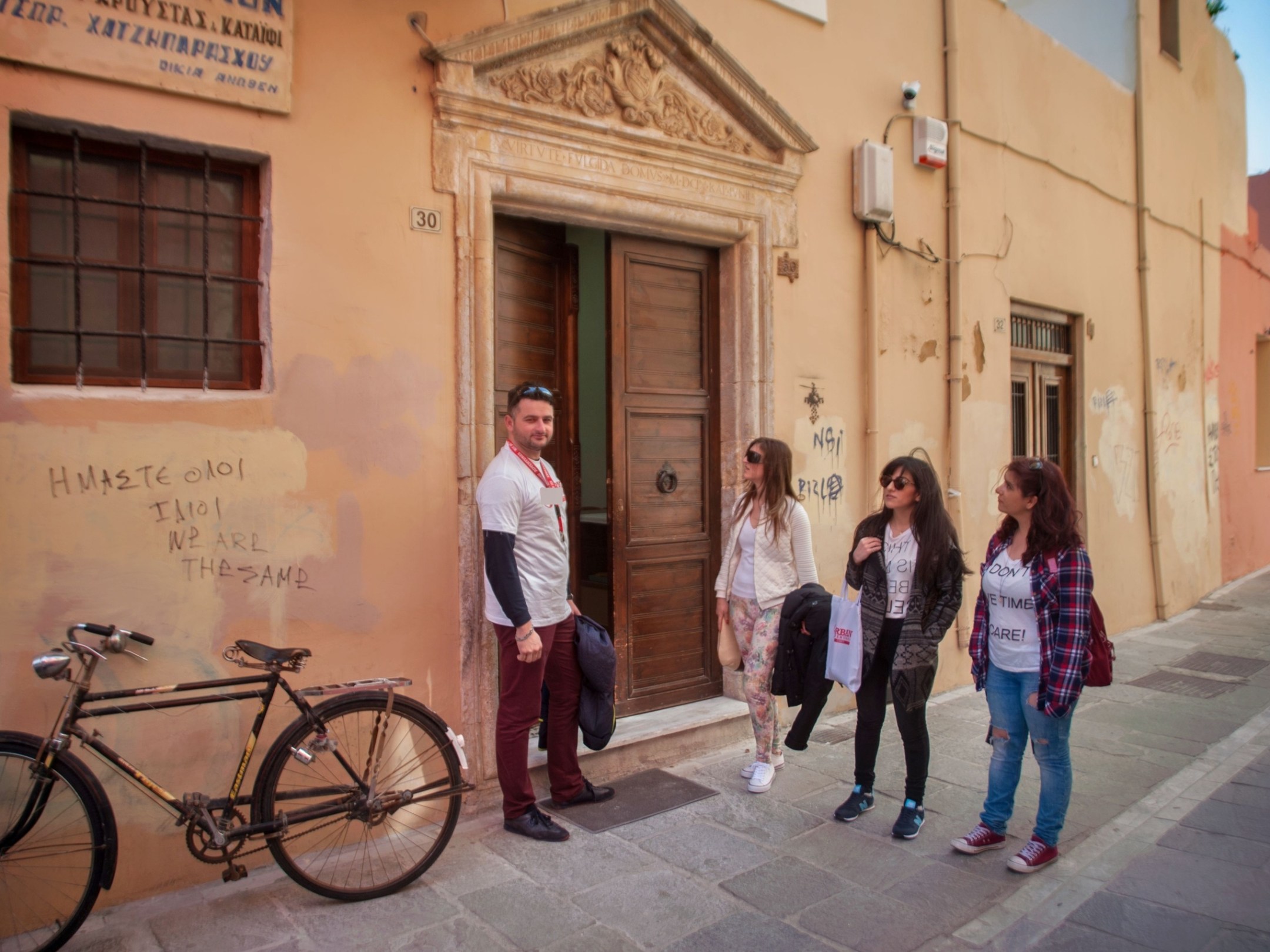 a man and a woman walking down a street next to a bicycle