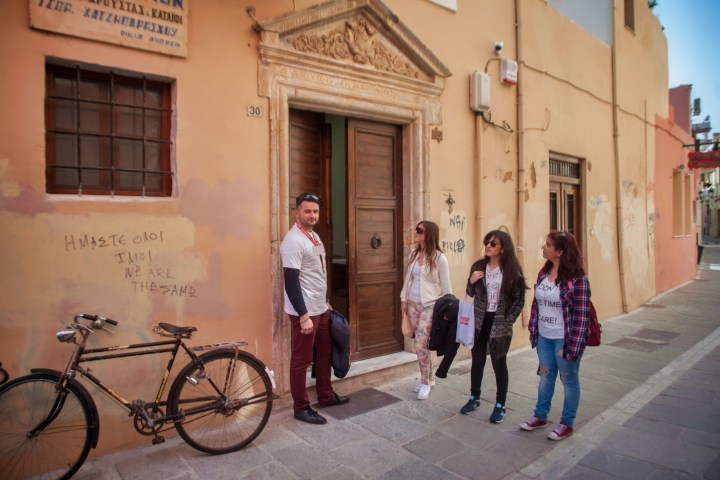 a man and a woman walking down a street next to a bicycle