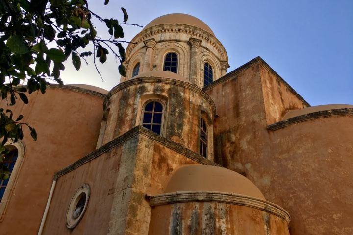 a stone church with a clock on the side of a building