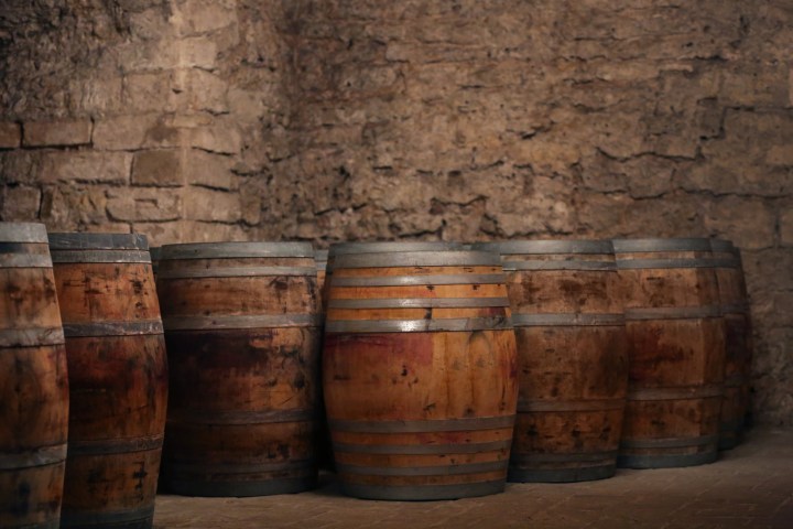 a barrel sitting next to a brick wall