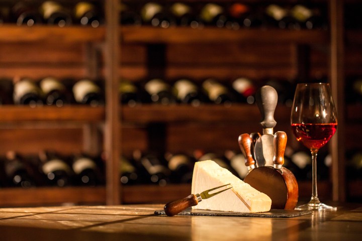 a glass of wine sitting on top of a wooden table