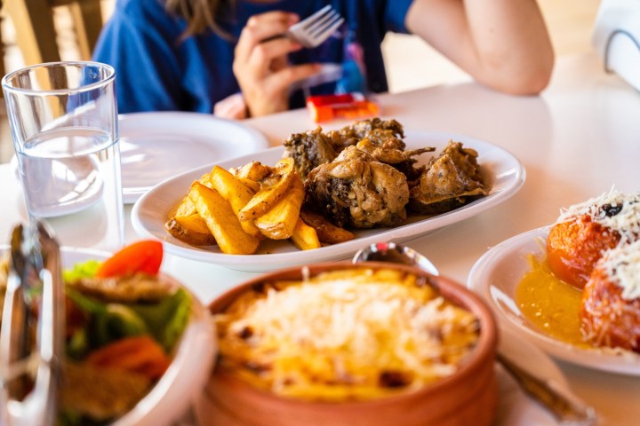 a person sitting at a table with a plate of food
